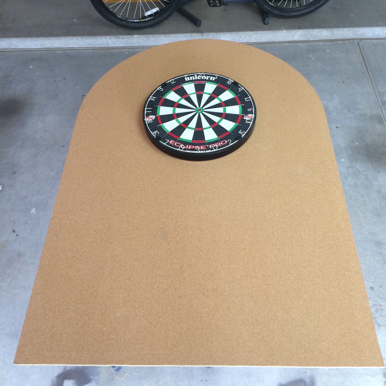 Cork board trimmed, dartboard centered in arc toward top